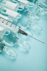 Syringe and ampoules with antibiotics on a blue background.