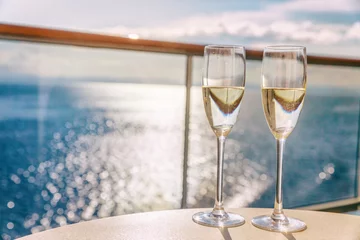 Gordijnen Luxury cruise ship travel champagne glasses on balcony deck with ocean sunset view on Caribbean vacation. Drinks in sun flare on cruise holiday destination. © Maridav
