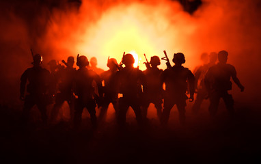 Fototapeta na wymiar War Concept. Military silhouettes fighting scene on war fog sky background, World War Soldiers Silhouettes Below Cloudy Skyline At night. Attack scene. Armored vehicles. Tanks battle.
