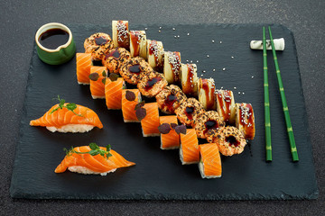 Sushi Set nigiri and sushi rolls on gray stone slate on metal background