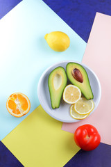 Avocado, lemon and half orange on a colorful background, tropical fruit pop art, vegetarian breakfast, Asian cuisine, avocado pop art, citrus, orange with avocado, art