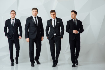 Group of four men in suits white background