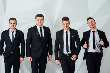 Group of four men in suits white background