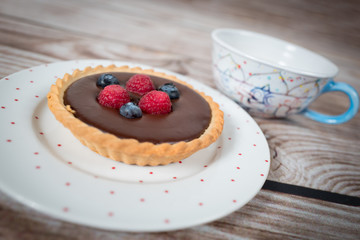 Cake for chocolate lovers with blueberries and raspberries on top