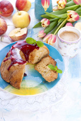 A bouquet of fresh tulips. Sweet home cupcake with sugar. Coffee in a cup. Apples on the table.