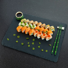 Sushi Set nigiri and sushi rolls on gray stone slate on metal background
