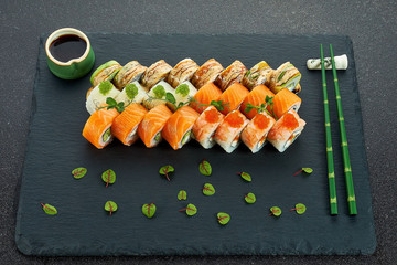 Sushi Set nigiri and sushi rolls on gray stone slate on metal background