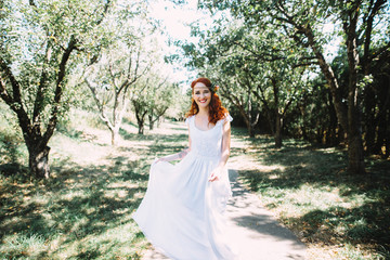 Portrait of a beautiful bride in a wedding dress. The red-haired bride laughs
