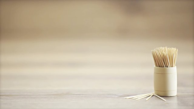 Sliding over toothpicks on wooden desk in studio 4K
