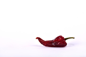 A single dried hot pepper on a white background.