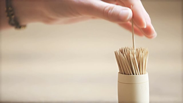 Picking sharp toothpick from retro style case close up 4K
