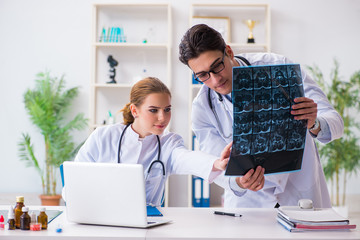 Two doctors examining x-ray images of patient for diagnosis