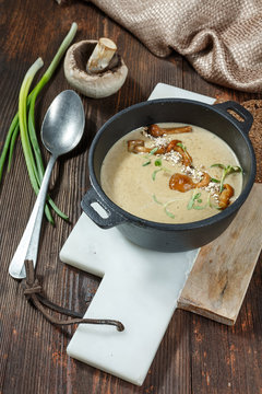 Cream soup with mushrooms and fresh chanterelles mushroom on wooden rustic background