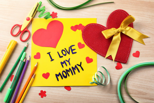 Cute handmade card with text I LOVE MY MOMMY on wooden table. Mother's day celebration