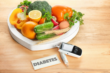 Digital glucometer, lancet pen, fruits and vegetables on table. Diabetes diet
