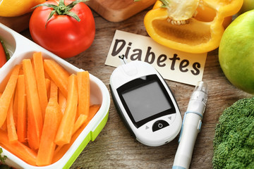 Digital glucometer, lancet pen and products on table. Diabetes diet