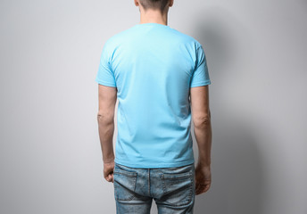 Man in blue t-shirt on light background. Mock up for design