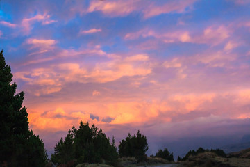 Red, orange, yellow clouds, with blue sky