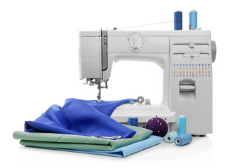Modern sewing machine with threads and fabrics on white background