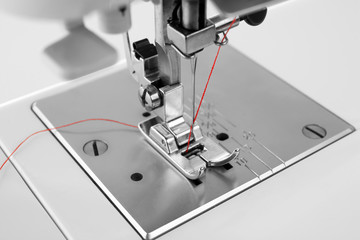 Modern sewing machine with thread, closeup