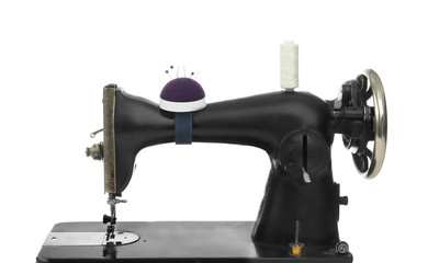 Old sewing machine with thread on white background