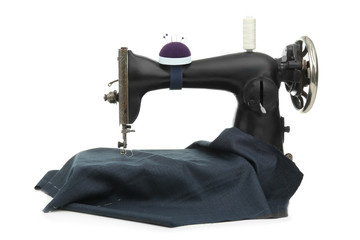 Old sewing machine with fabric and thread on white background