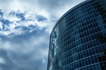 Detail blue glass building background with cloud sky