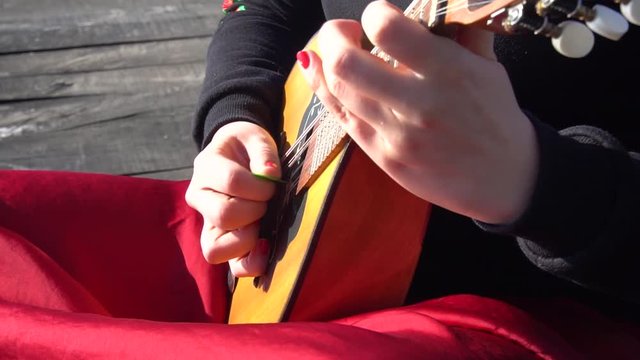 Woman wearing red dress playing mandoline