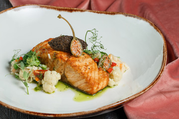 grilled salmon with lime, asparagus and cherry tomatoes on white plate