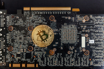 Bitcoins lie on the video card, concept of mining. Electronic virtual money for web banking and international network payment. Symbol of crypto currency