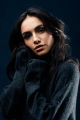 Young beautiful woman in a black sweater posing in studio