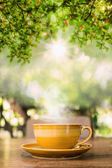 hot coffee cup on old wood table in natural background.