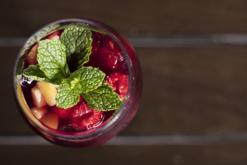 Purple fruit cocktail with raspberry and pineapple garnished with mint
