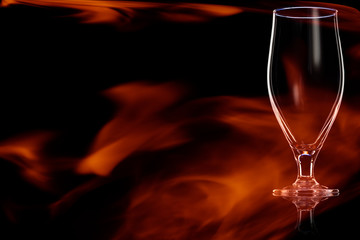 Empty glass of beer in the fire flames.