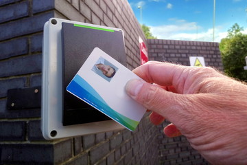 Green light on an electronic card reader, showing a man being allowed access to a secure location