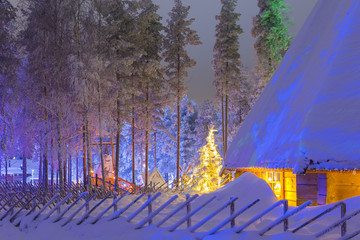 Travel Concepts and Ideas. Marvelous Lapland Houses in Suomi Village in Front of Marvelous Highlighted Winter Forest Scenery.