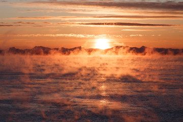 Fototapeta na wymiar Cloudy sunrise over mountainous seacoast