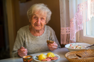 Elderly woman dines at home.