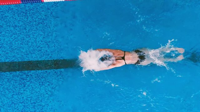 A woman reaches the end of the swimming lane. 