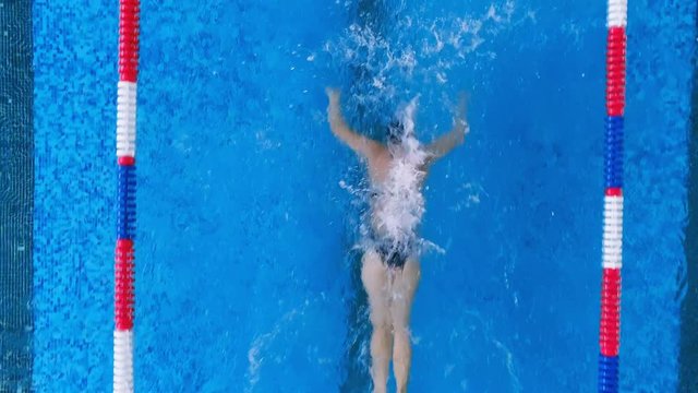A woman reaches the end of the lane underwater makings. 