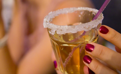 A female person holds a drink with sugar on the rim