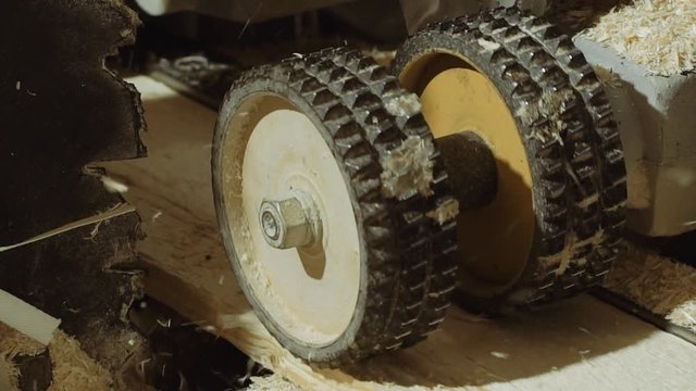 Spinning spiked wheels of board refiner machine working on wood at sawmill factory, close up