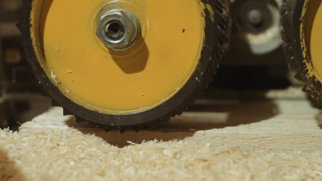 Spinning spiked wheels of plank refiner machine working on wood at lumber factory, close up