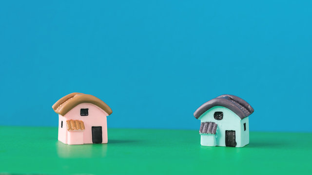 Two miniature house on a color table.