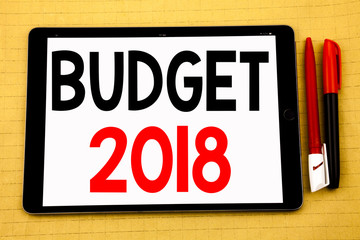 Conceptual handwriting text caption inspiration showing Budget 2018. Business concept for Household budgeting accounting planning Written on tablet laptop, wooden background with sticky note and pen