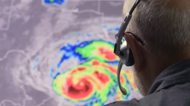 Weather man tracking a tropical storm on  computer screen