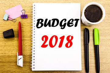 Hand writing text caption showing Budget 2018. Business concept for Household budgeting accounting planning Written on notepad note paper background with space office view with pencil marker coffee