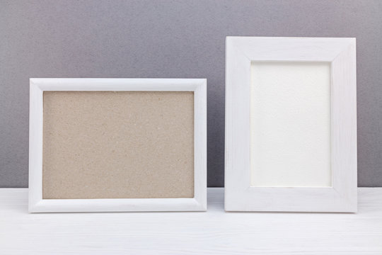 horizontal and vertical white wooden empty photo frames on grey background
