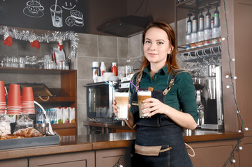 Barista woman with two glasses of coffee in her hands
