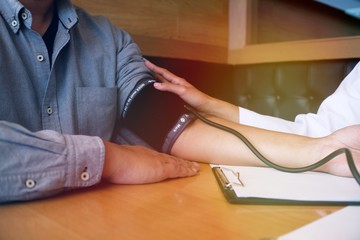 Doctor checking  patient arterial blood pressure. Health care
